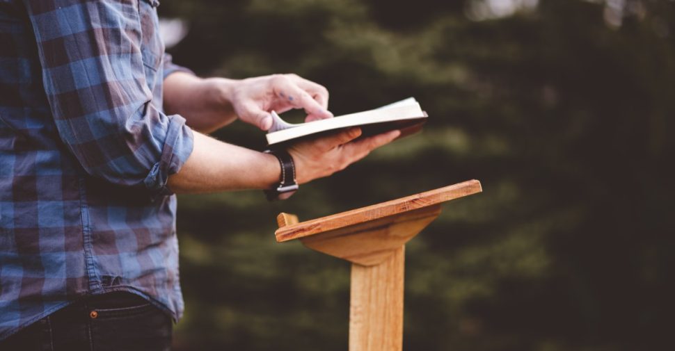 person-reads-book-on-lectern-outdoors-2026-09-21-18-23-31-utc-3